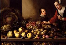 Girl selling grapes from a large table laden with fruit and vegetables