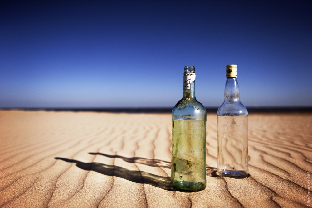 Flaschen auf Sand von Wim Schuurmans